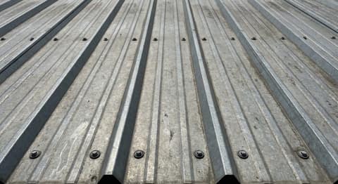 Close-up picture of ribbed metal panel (r-panel) roofing showing the texture and profile of the material